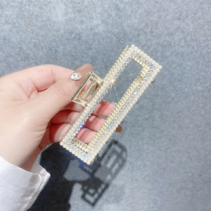 Détail d'une pince à cheveux en métal ornée de perles et de strass brillants