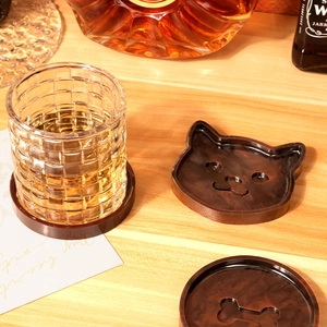 Detailed view of tortoiseshell resin coasters with cat and bone patterns on wood table
