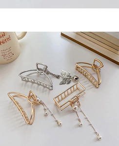 Detailed shot of gold and silver metal hair claws with pearl tassels and butterfly pendants