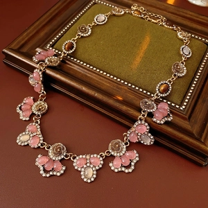 Detail of luxury gold flower necklace with pink gems and crystals in a vintage frame