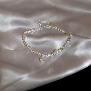 Dettaglio ravvicinato del ciondolo a cuore e della perla su bracciale in argento