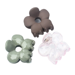 Three elegant flower hair claws in matte brown, glossy green, and transparent pink colors