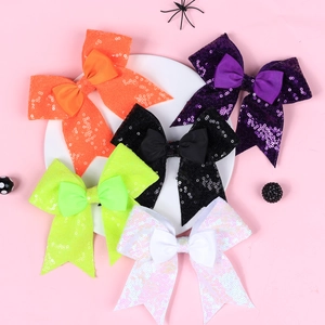 Five-piece set of Halloween sequin bow hair clips in vibrant festive colors on a display plate