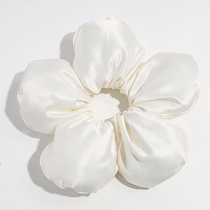 Close-up of white satin oversized flower scrunchie showing glossy texture and petal detail