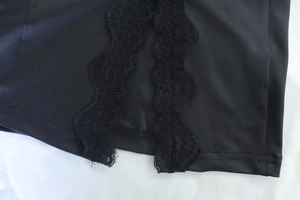 Close-up detail of delicate black lace trim and silky fabric on a bodycon dress