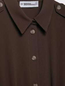 Close-up of deep brown shirt collar with shoulder straps and tortoiseshell buttons