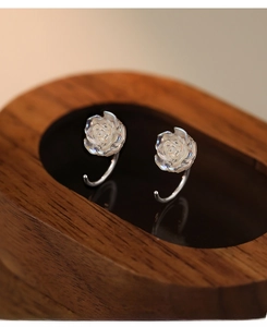 Detailed macro view of S999 sterling silver rose earrings with iridescent petals