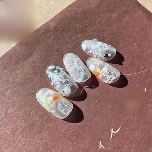 Detail of matte nail stickers with white snowflakes, pearls and 5D winter textures