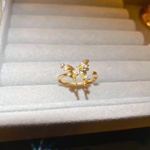 Close-up of gold-plated butterfly ring with sparkling zircons in a gray velvet jewelry box