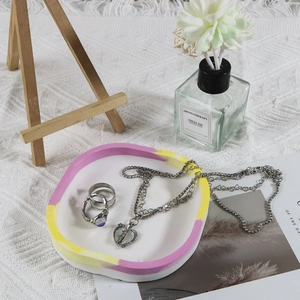 Silver jewelry set with heart necklace and rings on a stylish resin jewelry tray