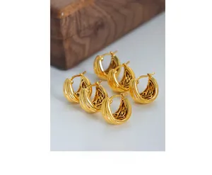 Detailed close-up of vintage U-shaped 18K gold plated hoop earrings with textured stripes