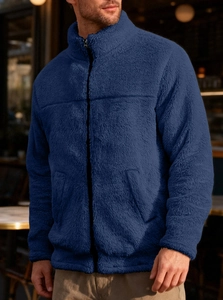 Detail of navy blue fleece jacket showing the high collar and metal zipper texture