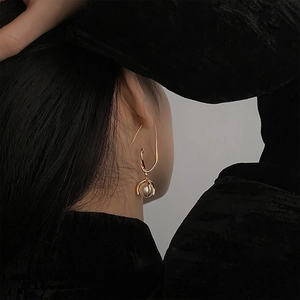 French vintage pearl drop earrings with elegant gold hooks shown on a model side profile