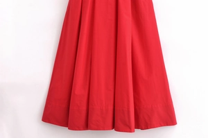 Detailed close-up of vibrant red woven poplin dress hem with high-quality stitching