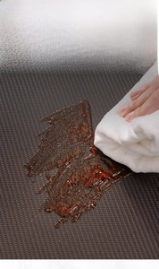Detail showing an easy-to-clean brown PU leather kitchen mat being wiped with a cloth
