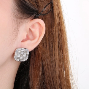 Close-up of a silver square earring with star-textured rhinestones on a female model