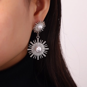 Vintage silver sunburst drop earrings with pearls on model's ear