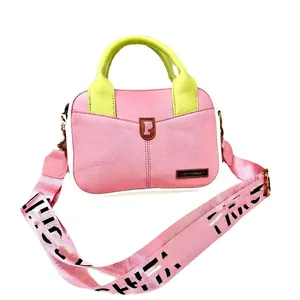 Pink and green crossbody bag with textured leather and wide lettered strap for daily commute
