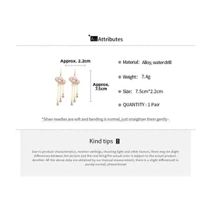 Detail view of sparkly star tassel earrings with pink stones and size measurements