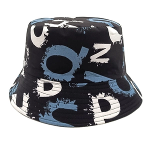 Détail du chapeau bob noir avec lettres graffiti blanches et bleues et coutures renforcées