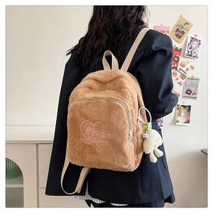 Close-up of brown plush backpack featuring pink heart embroidery and a small chick charm