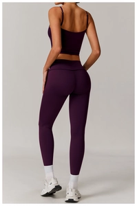 Back view of dark purple yoga set with thin strap sports bra and high-waisted leggings