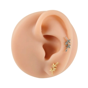 F136 titanium leaf flower labret stud earrings in gold and silver finish shown on ear