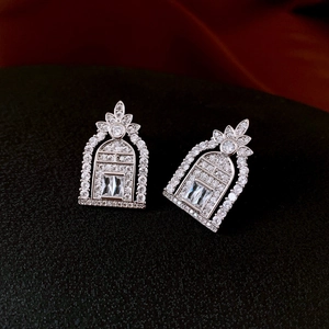 Macro shot of silver arch-shaped stud earrings with sparkling cubic zirconia stones