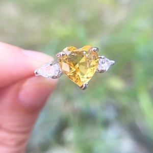 Elegant heart-shaped yellow gemstone ring with teardrop side diamonds on a silver band