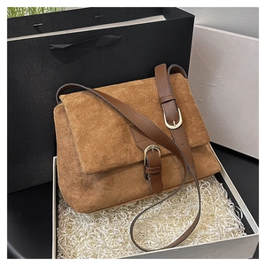 Brown faux suede crossbody bag with leather trim and gold metal buckle in a gift box