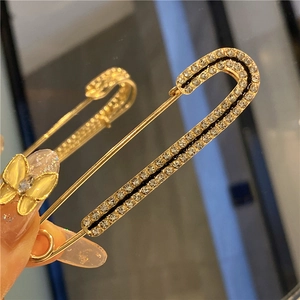 Macro shot of gold decorative pin with sparkling rhinestones used for waist adjustment