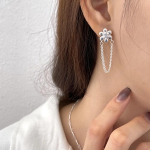 Close-up of 925 sterling silver flower earrings with elegant hanging tassel chains