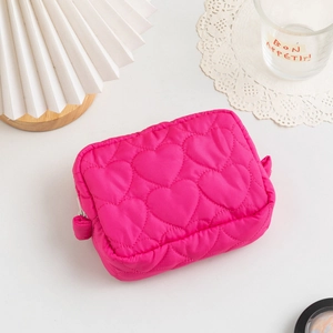 Close-up of heart-quilted magenta makeup pouch with soft padding and zip closure