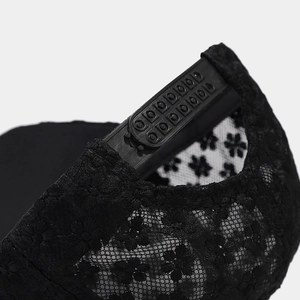 Detail des verstellbaren Verschlusses und Blumen-Spitzennetz der schwarzen Kappe