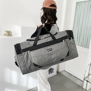Detailed view of grey nylon travel bag with multiple pockets and SPORT logo on model