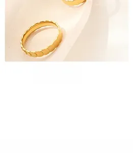 Détail d'une bague dorée aux bords ondulés avec une texture minimaliste et raffinée