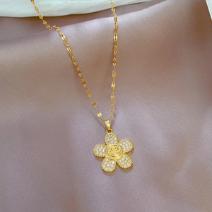 Detailed macro of gold flower pendant with smiley face and micro-inlaid stones