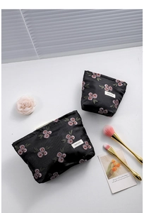 Detail of vintage black jacquard makeup bags with pink rose embroidery and H&R logo