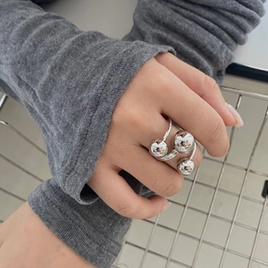 Close-up of silver triple gold bead open ring with minimalist three-layer design on finger