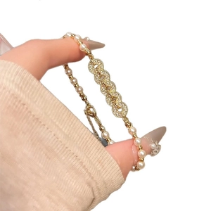Elegant gold pearl bracelet featuring zircon-inlaid interlocking rings with a lobster clasp