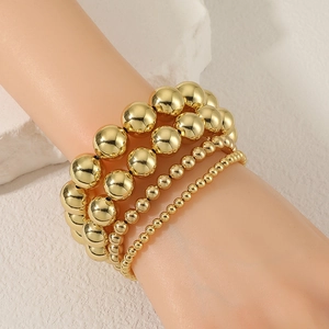 Set di quattro bracciali a sfere dorate per donna con perle di diverse dimensioni