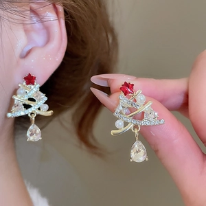 Macro view of Christmas tree earrings with red crystals, pearls, and pear-shaped drops