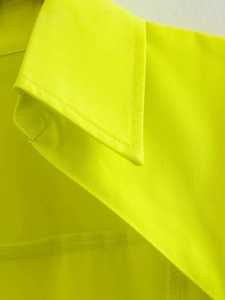 Gros plan du col jaune néon avec coutures de qualité et texture de tissu tissé