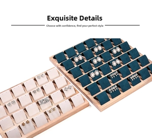 Detail of 24-slot wooden earring display trays with beige and green velvet linings