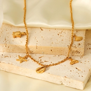 Golden stainless steel ocean theme necklace with starfish and shell pendants on stones