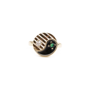 Golden yin yang heart ring with black enamel and colorful zircon stones on white background