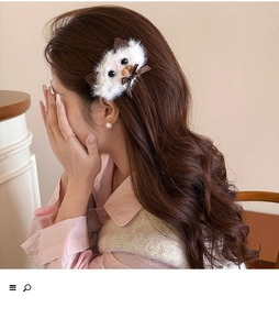 Detail view of a plush Siamese cat hair claw clip with bow on model's hair