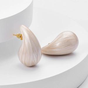 Minimalist pearly white marble drop earrings with gold studs on a geometric base