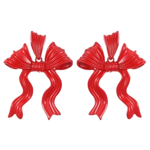 Macro detail of glossy red bow-knot stud earrings with premium enamel finish