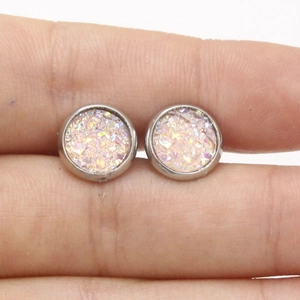 Detailed view of 8mm silver stainless steel stud earrings held to show actual scale